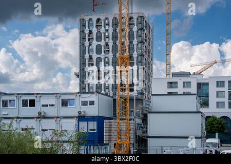 Modernes Hochhaus In Freiham München Bayern: Modernes Gebäude Mit Bogenfassade, Modularen Baustellencontainern Und Mehreren Gelben Baukranen Stockfoto