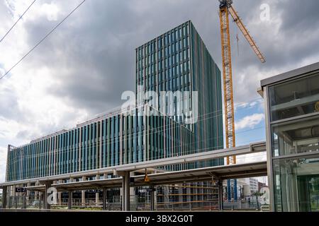 Modernes Hochhaus In Freiham München Bayern: Modernes Gebäude Mit Bogenfassade, Modularen Baustellencontainern Und Mehreren Gelben Baukranen Stockfoto