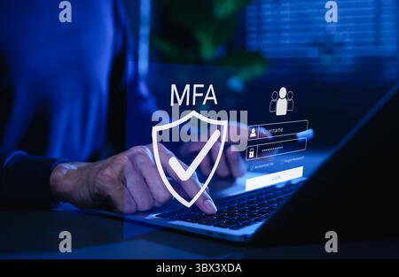MFA, Multi-Factor Authentication Security Concept. Person, die auf Laptop mit MFA-Schild-Symbol und Anmeldeschneidungsoberfläche, Multi-Faktor-Authentifizierung tippt Stockfoto