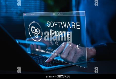 Software-Update und System-Upgrade-Konzept. Person, die das Telefon hält, während sie einen Laptop mit Software Update Progress Interface und Sicherheit, Technologie verwendet Stockfoto