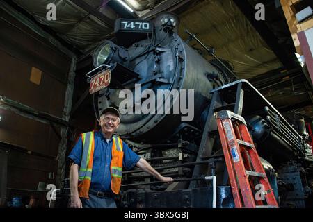 4. September 2021, North Conway, New Hampshire, USA: Eisenbahnpräsident David Swirk steht an der 1921 #7470 0-6-0 152 Tonnen Dampfmaschine, die am 4. September 2021 repariert wird, um weitere 100 Jahre auf den Gleisen zu laufen und Touristen, Eisenbahnfans und Historiker gleichermaßen zieht. Die Eisenbahn betreibt alte Eisenbahnausrüstung von der Dampfzeit bis zur Dieselzeit und gibt den Menschen die Möglichkeit, zu sehen, wie es war, Züge während der goldenen Ära der Zugfahrt zu fahren. Die Eisenbahn hofft, die Dampfmaschine wieder zu haben Stockfoto