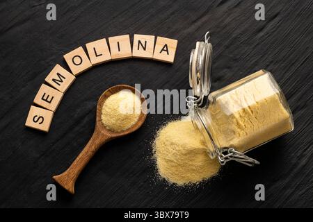 Grobes Weizen-Grießmehl in einem Glas und Löffel - Triticum Stockfoto