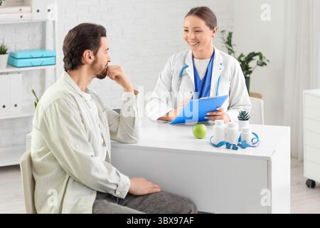 Ernährungsberaterin, die mit dem Mann in der Klinik arbeitet Stockfoto