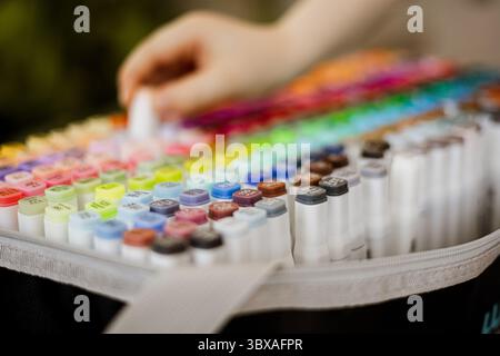 Hand-Picking bunten Marker aus Kunstzubehör-Kasten, Nahaufnahme von alkoholbasierten Markern Stockfoto