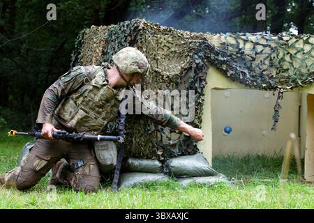 14. Juli 2025 - Baltimore, Maryland, USA - SPC. Jaden T. Hughes, ein Versorgungsspezialist in der Alabama Army National Guards 731st Combat Sustainment Support Company, setzt eine Handgranate für die Ausbildung ein, die während des National Best Warrior Competition 2025 am 14. Juli 2025 in Blum Military Reservation, Maryland, durchgeführt wurde. Die Army National Guards 2025 National Best Warrior Competition, veranstaltet von der Maryland National Guard, ist eine jährliche Veranstaltung, bei der Soldaten und Unteroffiziere aus sieben Regionen der USA zusammenkommen. Wettbewerber stehen vor einer anspruchsvollen Reihe von physischen und Stockfoto