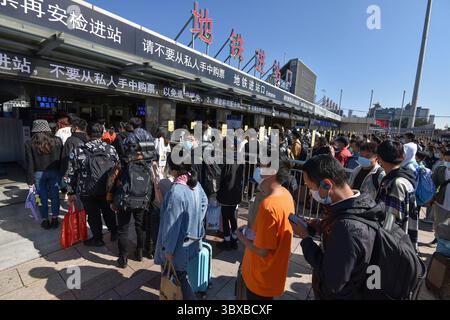 7. Oktober 2021, Peking, China: Viele Passagiere, die Gesichtsmasken trugen, um die Ausbreitung von covid-19 zu verhindern, werden als unterwegs mit Gepäck auf dem Platz vor dem Pekinger Bahnhof gesehen. Am letzten Tag des chinesischen Nationalfeiertags führte die Eisenbahn den Höhepunkt des Rückflugs von Fahrgästen, die Nationalbahn soll voraussichtlich 13,5 Millionen Passagiere und 1448 zusätzliche Personenzüge entsenden. (Kreditbild: © SheldonÂ Cooper/SOPA Bilder über ZUMA Press Wire) Stockfoto