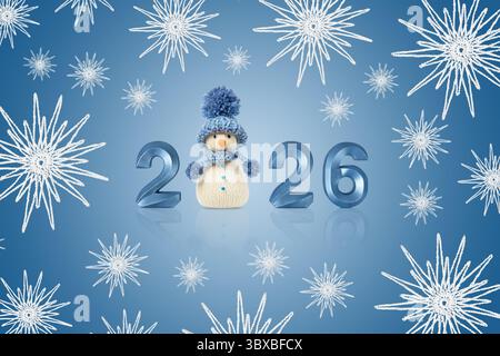 Weihnachtskarte mit Schneemann, Zahlen 2026 und weißen Schneeflocken auf blauem Hintergrund. Wintermärchen mit eigenen Händen, Hobby. Frohe Weihnachten Stockfoto