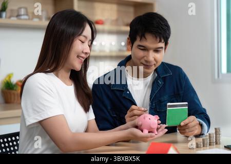 Finanzielle Befähigung und Budgetierung. Ein junges Paar, das Sparen mit Sparkasse und Finanzplaner diskutiert. Stockfoto