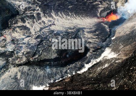 8. Oktober 2021 - Big Island, Hawaii, USA - auf diesem Überflugsfoto des Halemaumau Lavasees, aufgenommen am 8. Oktober 2021 und von Nordosten aus gesehen, sind zwei westliche Risse sichtbar: Eine inaktiv vom Dezember 2020 bis Mai 2021 Kilauea Gipfelausbruch (Mitte) und eine andere aktiv Lava in den See einspeist (oben rechts). Die alte Spalte ist teilweise von kurzen Lavaströmen überlappt, wurde aber nicht vollständig ertrunken, da Feldmessungen zeigen, dass sie im See schwimmt. Die derzeit ausbrechende Spalte hat einen hufeisenförmigen Spritzkegel gebildet Stockfoto