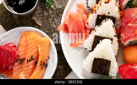 Verschiedene Sushi-Nigiri- und Maki-Sets. Eine Auswahl an japanischem Sushi mit Thunfisch, Krabben und Lachs auf hellem Hintergrund. Draufsicht. Stockfoto