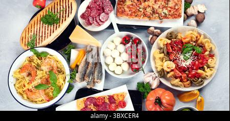Traditionelle italienische Gerichte mit Pizza, Pasta, Oliven, Gemüse. Gesunde mediterrane Ernährung. Panorama, Banner Stockfoto