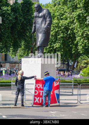 „Stop Brexit man“ Steve Bray, bekannt für seine lautstarken Anti-Brexit-Proteste, entfaltet ein Banner gegen den Brexit neben der Winston Churchill Statue in Westminster, London, Großbritannien. Bray ist seit dem EU-Referendum 2016 eine prominente Persönlichkeit im britischen politischen Aktivismus. Stockfoto