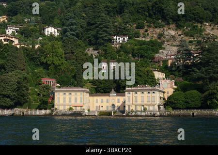 Luxuriöse historische Villen am Ufer des Comer Sees in Italien, umgeben von dichtem Grün und Bergen. Stockfoto