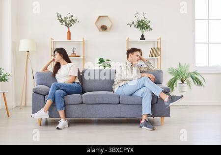 Familienpaar, das auf der Couch sitzt, beleidigt und traurig zu Hause Stockfoto