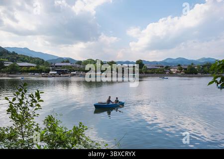 Die Menschen genießen es, kleine Boote auf einem ruhigen Fluss in Arashiyama, Kyoto, Japan zu rudern. Kyoto, Japan.06.29. 2025. Stockfoto