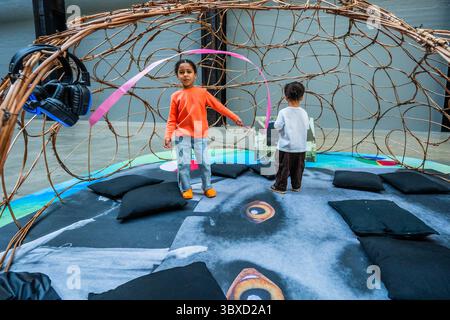 London, Großbritannien. Juli 2025. Kinder werden von den Bildschirmen in den Hörkuppeln angezogen – Thunder, Crackle und Magic The UNIQLO Tate Play: Monster Chetwynd bei Tate Modern. Es ist eine neue interaktive Installation in der Turbine Hall, inspiriert von Ingmar Bergmans Film die Zauberflöte aus dem Jahr 1975. Das verspielte Erlebnis findet in drei fantastischen Sets statt, die jeweils ein lebendiges Spektakel mit Darstellern, Kreaturen, Kostümen und handgefertigten Requisiten bieten. Besucher werden aufgefordert, sich zwischen der Bühne und hinter den Kulissen hin und her zu bewegen. Es ist vom 19. Juli bis 25. August 2025 geöffnet. Guy Bell/Alamy Live Stockfoto
