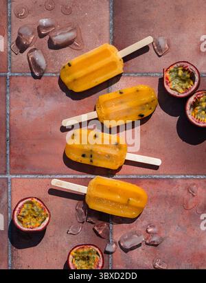 Blick von oben auf Passionsfrucht-Eis auf Terrakotta-Fliesen in der Sonne. Stockfoto