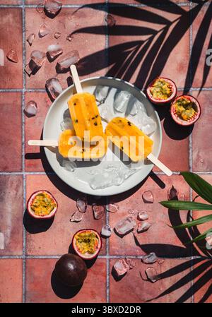 Blick von oben auf Passionsfrucht-Eis auf Terrakotta-Fliesen in der Sonne. Stockfoto