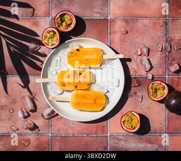 Blick von oben auf Passionsfrucht-Eis auf Terrakotta-Fliesen in der Sonne. Stockfoto