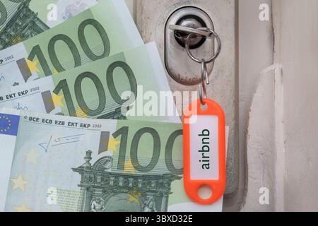 Ein Schlüssel steckt im Türschloss, am Anhänger prangt der Schriftzug Airbnb, daneben liegen Euro-Scheine. Das Bild verweist auf die wirtschaftlichen Aspekte der Kurzzeitvermietung und den Einfluss von Plattformen wie Airbnb auf Wohnungsmarkt und Tourismus. *** Ein Schlüssel steckt im Türschloss, die Worte Airbnb prangen auf dem Etikett und daneben stehen Euro-Banknoten. Das Bild bezieht sich auf die wirtschaftlichen Aspekte der kurzfristigen Vermietung und den Einfluss von Plattformen wie Airbnb auf den Wohnungsmarkt und den Tourismus. Nordrhein-Westfalen Deutschland, Deutschland DSCF6663 Stockfoto
