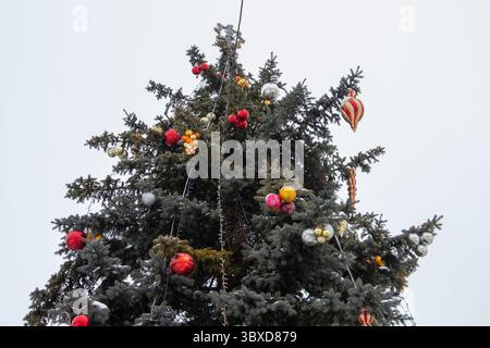 Wunderschöner Weihnachtsbaum mit alten Kugeln dekoriert und mit Schnee bedeckt Stockfoto