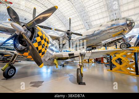 CHANTILLY, Virginia — das Republic P-47D Thunderbolt Jagdflugzeug wird im Nationalen Luft- und Raumfahrtmuseum Udvar-Hazy Center des Smithsonian ausgestellt, wobei die Enola Gay im Hintergrund zu sehen ist. Diese P-47D-30-RA wurde 1944 an Godman Field, Kentucky, geliefert und diente als Luftwaffentrainer, bevor sie in das U.S. Air Force Museum und dann in das Smithsonian überführt wurde. Die P-47 Thunderbolt, angetrieben von einem 2.000 PS starken Pratt & Whitney R-2800-59 Double Wasp Radialmotor und mit acht Kaliber .50 Maschinengewehren bewaffnet, galt als einer der drei führenden amerikanischen Kämpfer von Wor Stockfoto