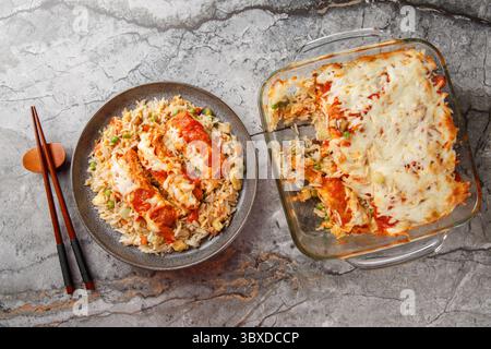 Baked Pork Chop Rice besteht aus einer Basis aus gebratenem Reis mit Ei, der mit Tomatensauce und Käse aus der Nähe auf einem Teller auf dem Tisch belegt wird. horizont Stockfoto