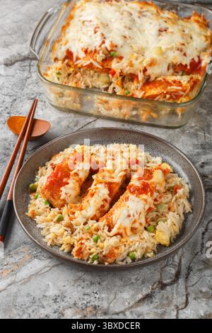 Baked Pork Chop Rice ist ein köstlicher Auflauf öøåð Ei gebratener Reis, Schweinekoteletts und eine Tomatensauce mit geschmolzenem Käse aus der Nähe auf einem Teller auf dem t Stockfoto