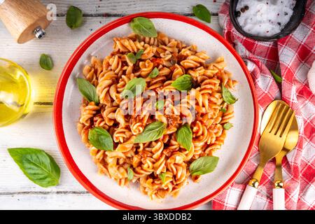 Fusilli-Pasta mit Bolognesauce, Hackfleisch, Pilzen, Tomaten und Basilikum. Traditionelles italienisches Mittagessen mit Pasta-Teller, mit Gewürzen serviert auf dem Stockfoto