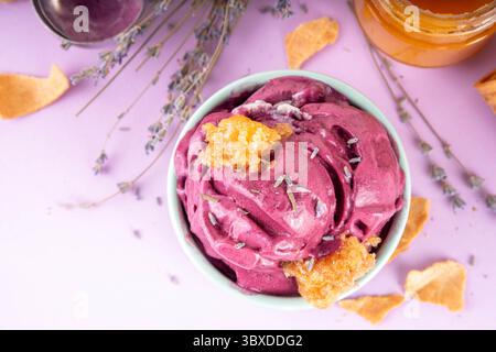 Süßes Lavendelhonig-Eis, cremiges Sorbet-Gelato mit Lavendelblüten und Sirup, Honig und Honigwaben. Ungewöhnliches handwerkliches lavandula-Eis c Stockfoto