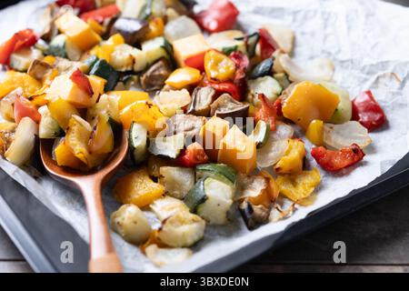 Geröstetes Gemüse auf einem Backblech auf schwarzem Hintergrund Stockfoto