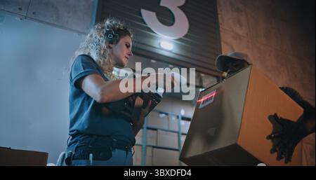 Verschiedene Mitarbeiter, die nachts Kartons aus dem Logistics Distribution Warehouse transportieren. Weibliche Manager scannt Pakete mit Barcode-Scanner mit Digital Tablet. Online-Bestellungen, Waren, Lieferung. Stockfoto