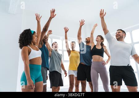 Multiethnische Gruppe von sportlichen Menschen, die funktionelles Workout in der Trainingsklasse Gym machen lächelnde männliche und weibliche Athleten feiern Fitness-Leistungen Stockfoto