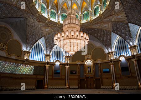 Luxuriöser Ballsaal mit großem Kronleuchter, gemusterten Bögen und komplizierten Wandpaneelen Stockfoto