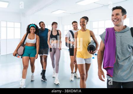 Multiethnische Gruppe von sportlichen Menschen, die funktionelles Training im Trainingsraum machen glücklich verschiedene Athleten, die das Fitnessstudio verlassen, nachdem sie ihre Funktion beendet haben Stockfoto