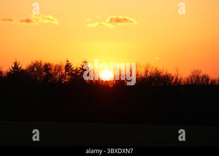 Dieses Bild zeigt eine ruhige Szene bei Sonnenuntergang. Die Sonne ist tief am Horizont. Stockfoto