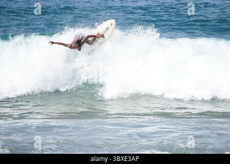 Surfer, der eine perfekte Welle an einem abgelegenen Strand fährt und das Wesen von Freiheit, Abenteuer und Verbindung mit der Natur festnimmt. Ein kraftvoller Moment des Surfens Stockfoto