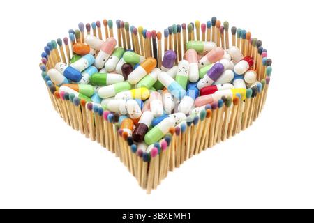 Eine Herzform aus mehrfarbigen Streichhölzern voller Arzneikapseln Stockfoto