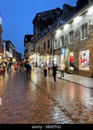 An einem verregneten Sommerabend genießen die Menschen Einkaufsmöglichkeiten in Souvenirläden und Boutiquen, während sie im Bistro und in Cafés in der Altstadt von Montreal speisen Stockfoto