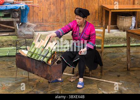 25. Mai 2014, Longshen, Region Guangxi, China: Eine Frau des roten Yao kocht Reis in Bambusröhren über einem offenen Feuer in Jinking, Longshen, China. (Kreditbild: © Jon G. Fuller/VW Pics via ZUMA Press Wire) Stockfoto