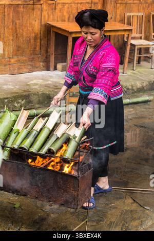 25. Mai 2014, Longshen, Region Guangxi, China: Eine Frau des roten Yao kocht Reis in Bambusröhren über einem offenen Feuer in Jinking, Longshen, China. (Kreditbild: © Jon G. Fuller/VW Pics via ZUMA Press Wire) Stockfoto