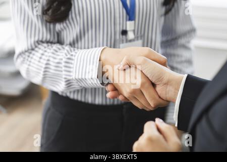 Eine Nahaufnahme eines Handschlags zwischen Geschäftsleuten, die Übereinstimmung und Zusammenarbeit in einer modernen Büroumgebung symbolisieren Stockfoto