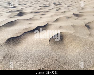 Nahaufnahme von Wüstensandwellenformationen mit scharfen und verschwommenen Texturen Stockfoto