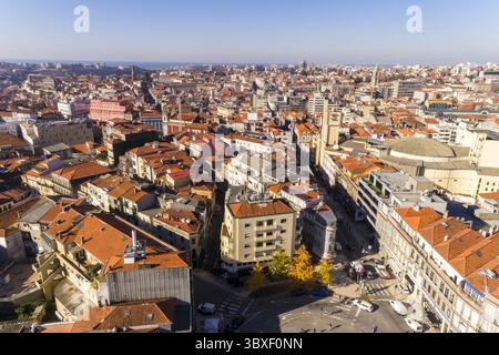 Blick aus der Vogelperspektive auf Terrakotta-Dächer, die zu sonnendurchfluteten Straßen in der Nähe des Bahnhofs São Bento, Porto, Porto District, Portugal. Stockfoto