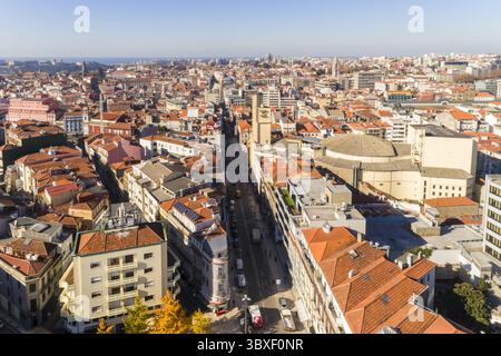 Blick aus der Vogelperspektive auf das warme Sonnenlicht, das die Brücke Dom Luís i und die Terrakotta-Dächer in Kontrast zum tiefen Blau des Flusses Douro, Porto, Porto, Portugal. Stockfoto