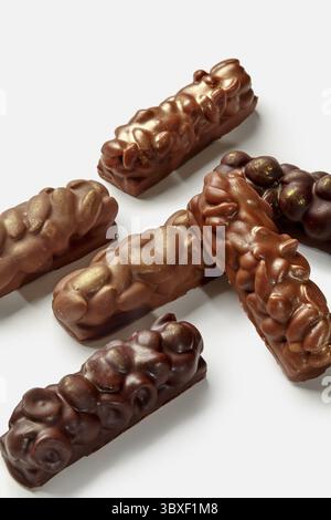 Verschiedene Tafeln aus Milch und dunkler Schokolade mit Mandeln, Erdnüssen und Haselnüssen auf weißem Hintergrund. Beliebtes süßes Snackkonzept Stockfoto