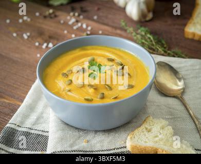 Vegetarisches Pupmkin Creme Suppe Püree, auf dunkelbraunem Holztisch, Seitenansicht, Nahaufnahme Stockfoto