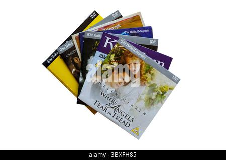 Ein Haufen kostenloser DVDs, die mit dem Daly Telegraph verschenkt werden, mit Where Angels Fear to Tread DVD oben isoliert auf weißem Hintergrund Stockfoto