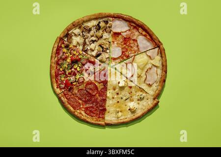 Runde Pizza, die in sechs Scheiben geschnitten ist, mit verschiedenen Belägen auf leuchtendem grünem Hintergrund Stockfoto