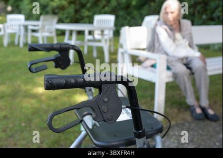 DEUTSCHLAND, Hamburg, alte Frau eines Pflegeheims im Garten mit Gehhilfe, Rollator Stockfoto